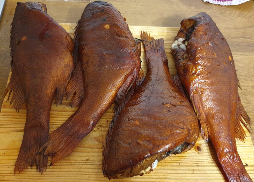 Karsti kūpināts jūras asaris kūpinātavā ar zeltainu ādu un dūmu aromātu