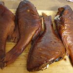 Karsti kūpināts jūras asaris kūpinātavā ar zeltainu ādu un dūmu aromātu